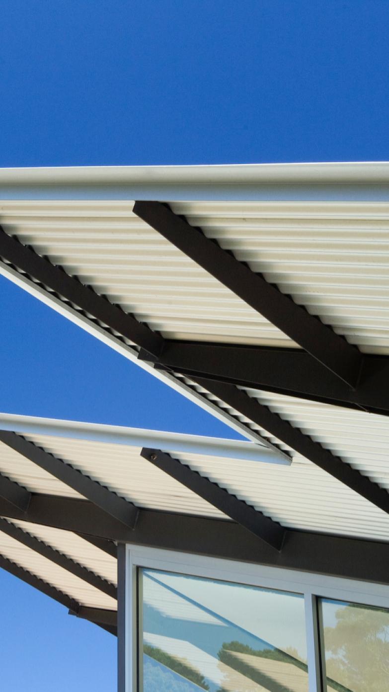 A photo of the generous eaves of the Bastian House, clad in Lysaght CUSTOM ORB®, set against a brilliant blue sky