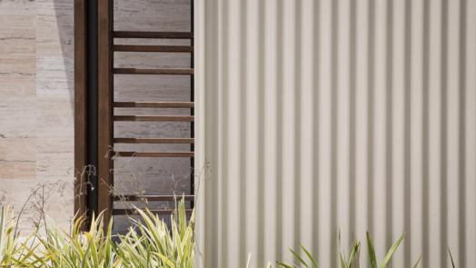Close up image of fence which sits next to a sandstone wall.
