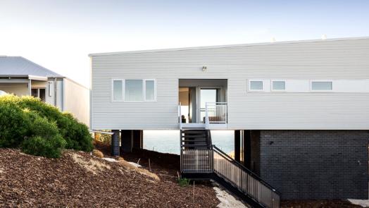 Contemporary stilted home with COLORBOND® Surfmist® walling, designed for coastal conditions and modern aesthetics.