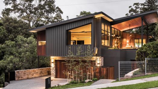Elevated modern house with COLORBOND® Monument® steel wall cladding and a striking angular roofline