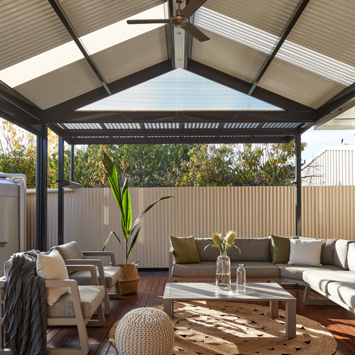 Interior view of a gable roof pergola made from COLORBOND® steel, featuring corrugated roof sheets and a ceiling fan.