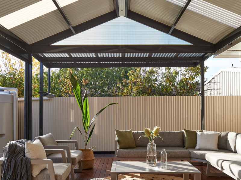 Interior view of a gable roof pergola made from COLORBOND® steel, featuring corrugated roof sheets and a ceiling fan.
